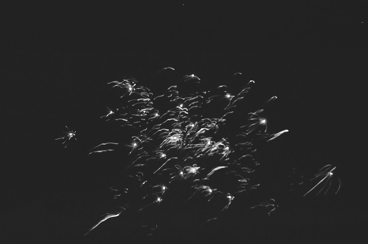 A black-and-white photo of white sparks on a dark background.